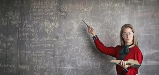 strict female teacher with book pointing at scribbled blackboard