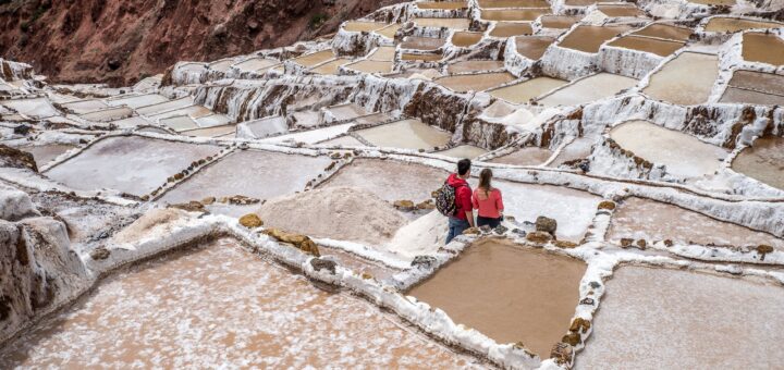 tourists visiting ancient saline terraces in andes peru