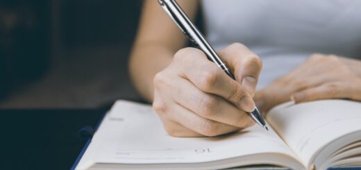 photo of person writing on notebook